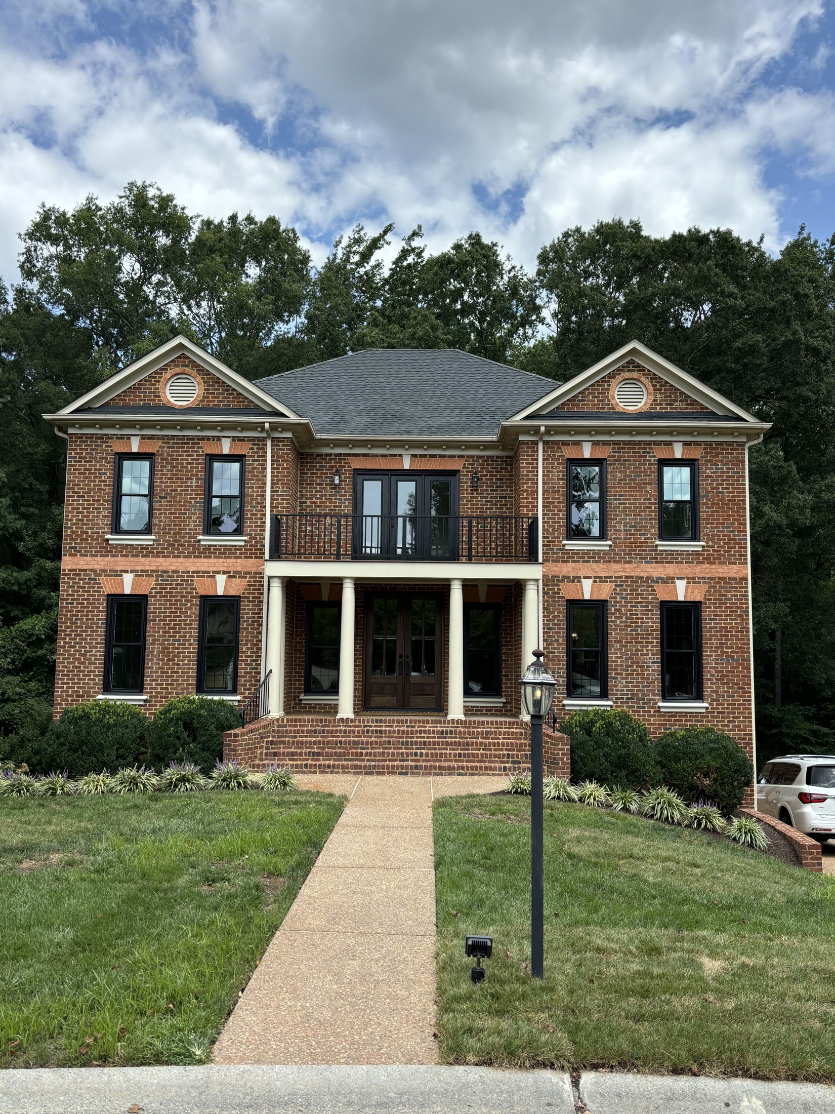 Brick home with black-framed windows and a welcoming front entrance