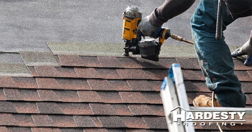 A Hardesty crew member fastening shingles with a coil nailer